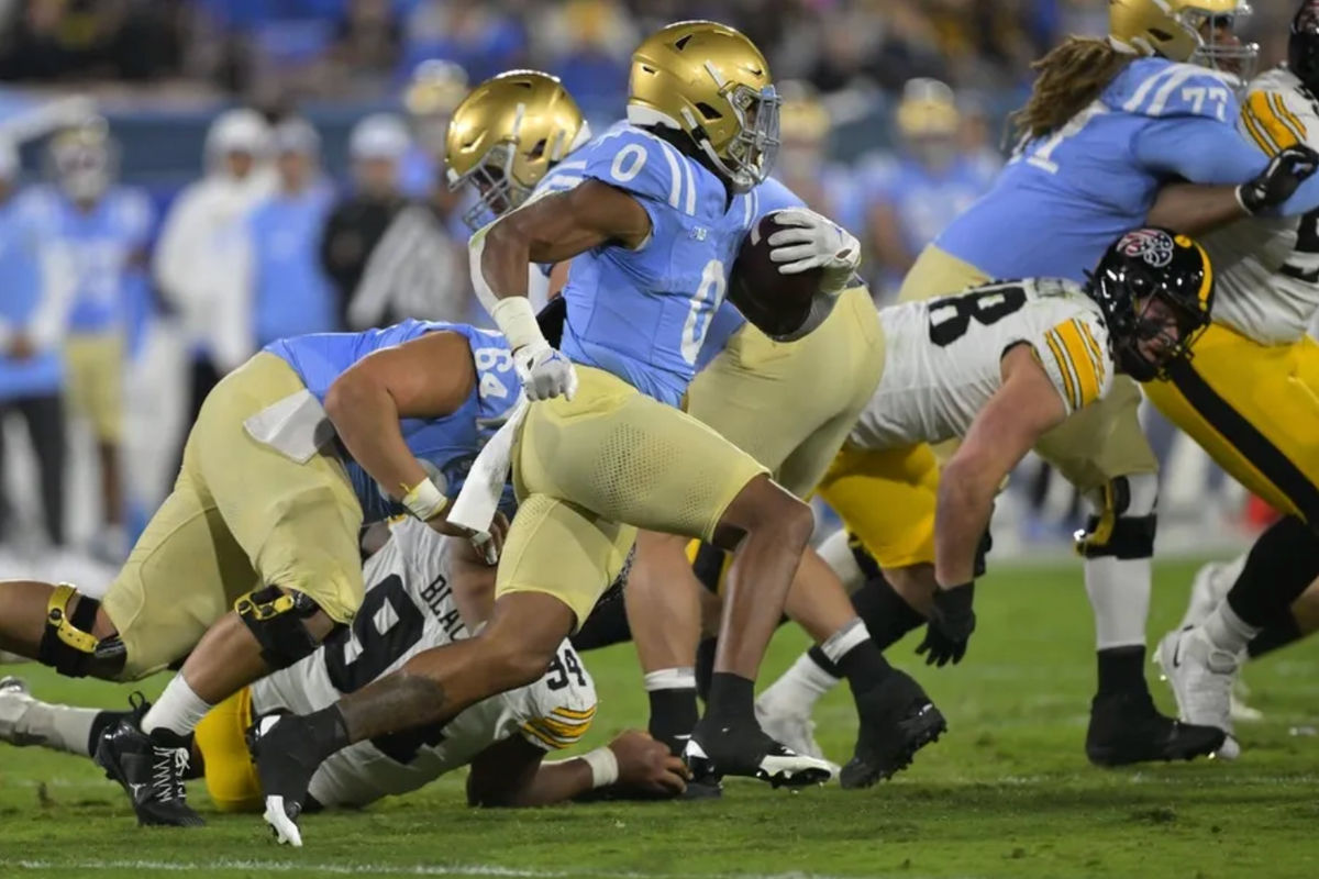 Nov 8, 2024; Pasadena, California, USA; UCLA Bruins running back Jalen Berger (0) carries for a gain in the first half against the Iowa Hawkeyes at the Rose Bowl. Mandatory Credit: Jayne Kamin-Oncea-Imagn Images