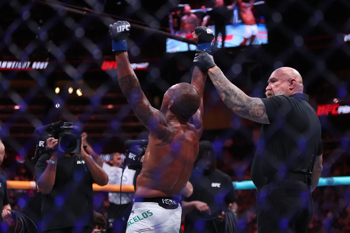 Jun 14, 2025; Atlanta, Georgia, UNITED STATES; Raoni Barcelos (blue gloves) reacts after defeating Cody Garbrandt (red gloves) during UFC Fight Night at State Farm Arena. Mandatory Credit: Brett Davis-Imagn Images